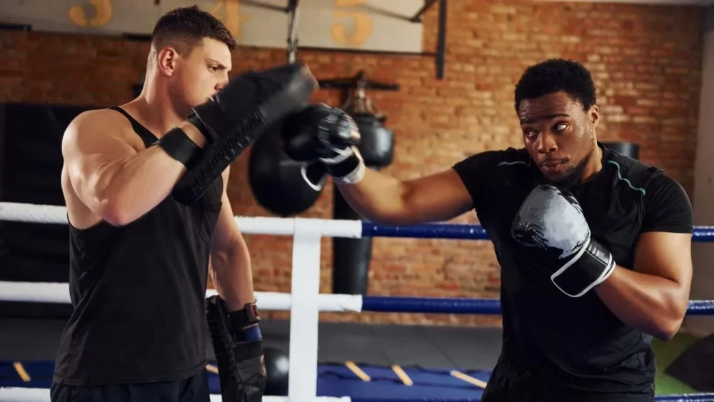 Image-of-a-man-practicing-body-blows-with-a-coach-in-a-mitt-strike